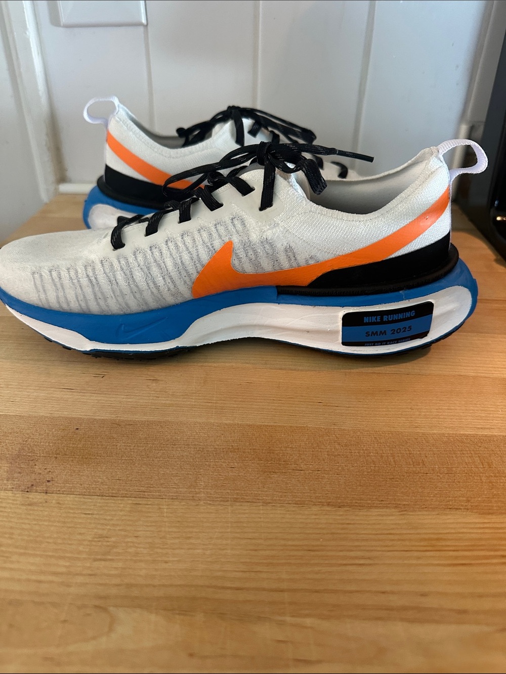 Nike White Knit Running Sneakers with Orange Swoosh and Blue Midsole